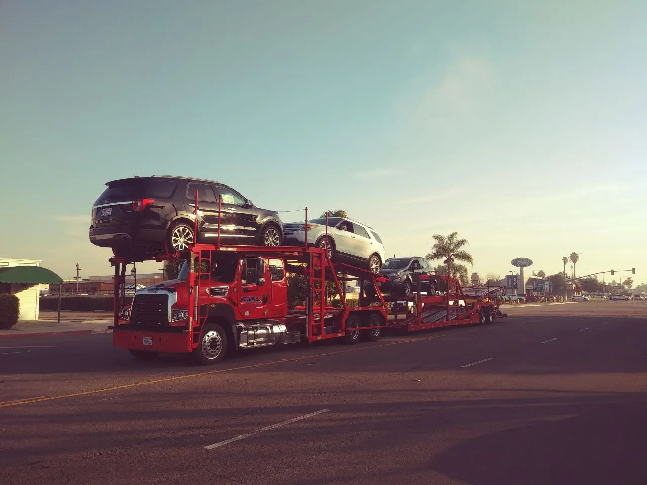 Open multi-car carrier with cars visible on two decks